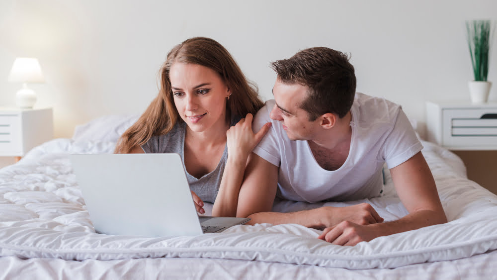 couple shop online in bed